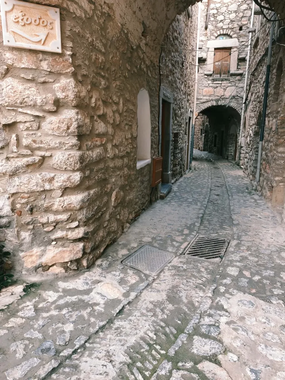 A narrow stone lane beneath arches in Mesta